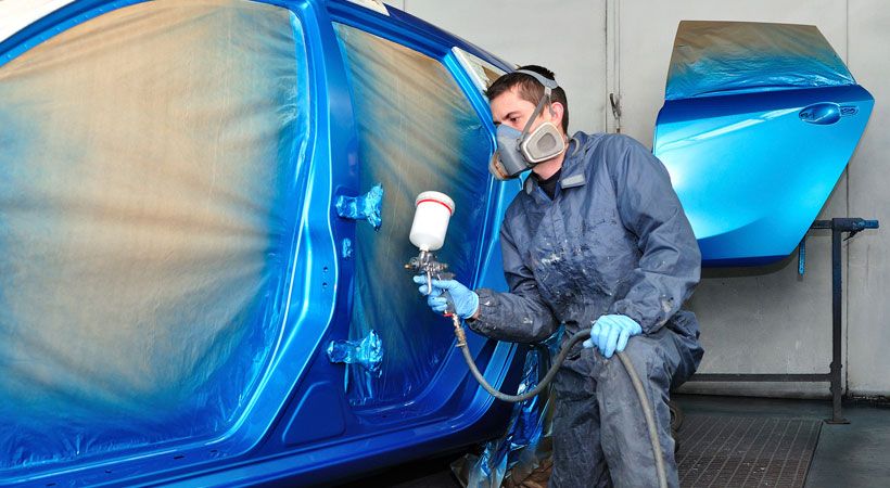 Hombre pintando auto de color azul